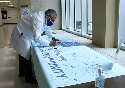 Dr. Paul Klotman signing banner