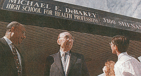 An older archival picture of the Michael E. DeBakey High School for Health Professionals, with Dr. DeBakey standing proudly under the main entrance sign.