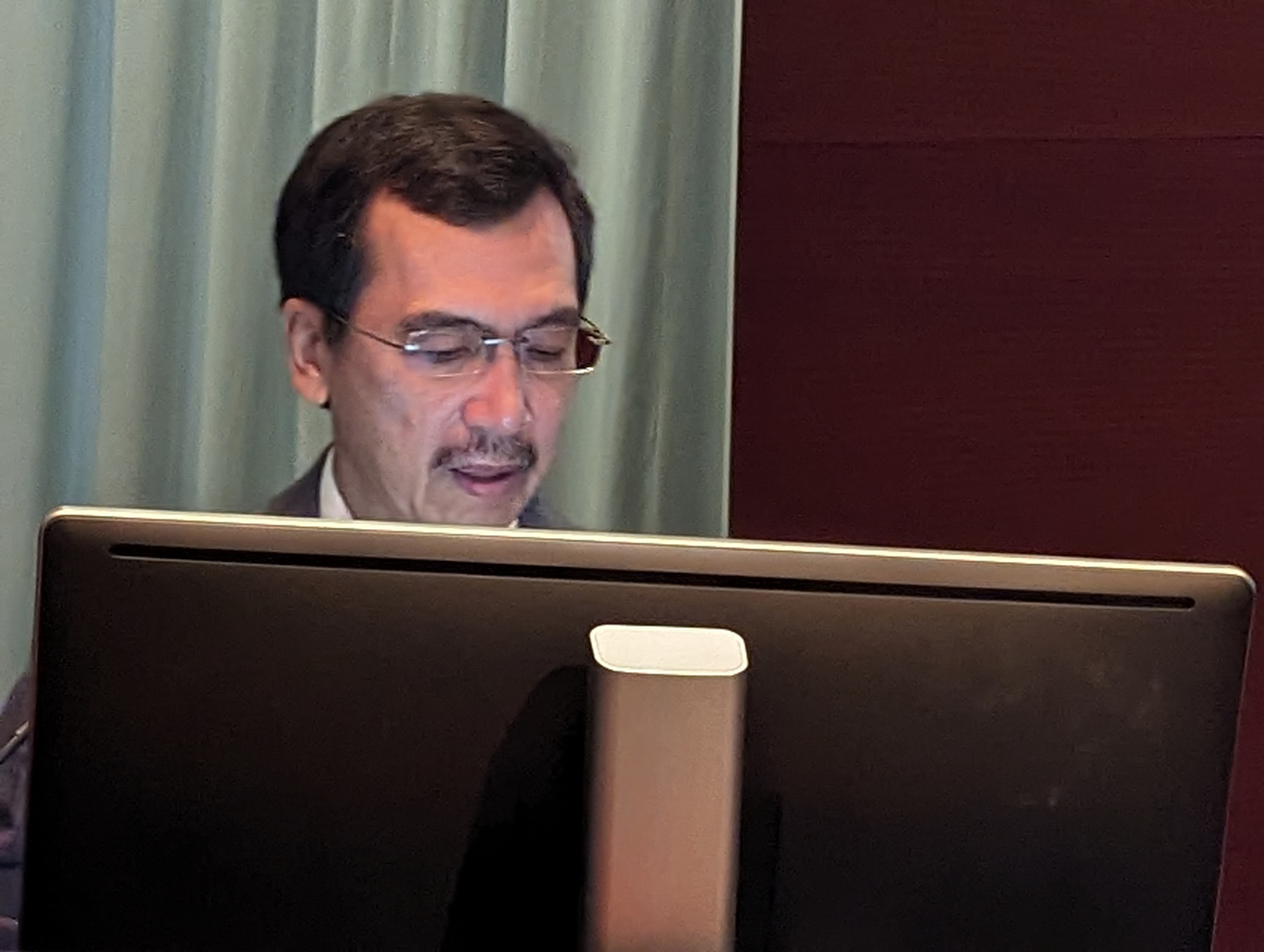 man speaking at symposium