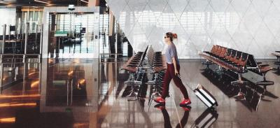 A person walks through an airport on the way to a holiday destination