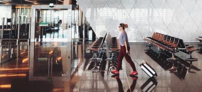 A person walks through an airport on the way to a holiday destination