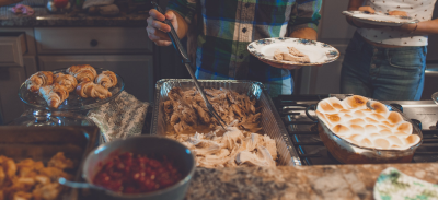 Individuals plating food during a holiday gathering.
