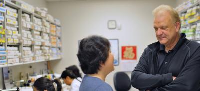 Dr. Hugo J. Bellen (right) talks with a colleague in a lab.