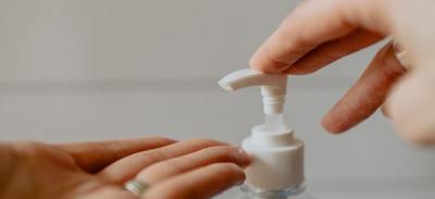 A person getting soap from a pump bottle to wash their hands.