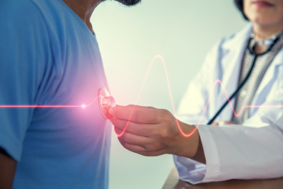 Doctor using a stethoscope to listen to patient's heart, graphic of heart beat displayed over image with red line. 