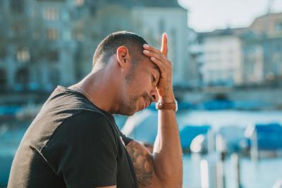 A man holding his head because his head hurts. 