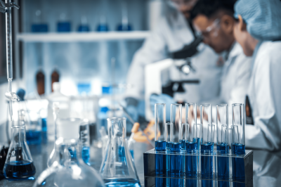 Scientists working in a lab filled with containers of blue liquid