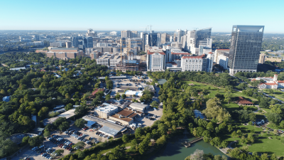 The Texas Medical Center as seen from the sky. Trees flank a row of buildings and parking lots, with taller building seen in the background