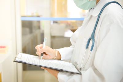 Photo of doctor writing on pad