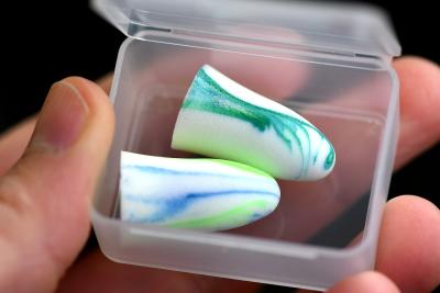Close up photo of blue and white earplugs in a plastic box container. 