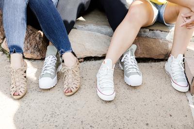 Three teens seated, focused on their shoes