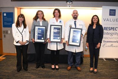 group of people holding award plaques smiling