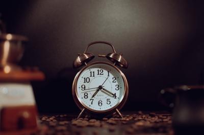 Photo of a clock surrounded by coffee beans
