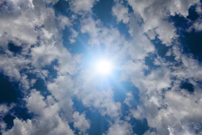 Photo of the sky showing the sun and clouds