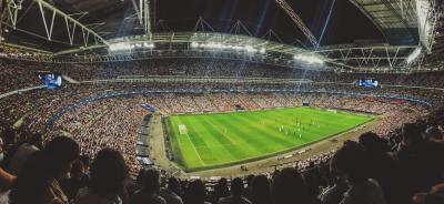 A wide shot photo of a soccer game showing the field and a full stadium