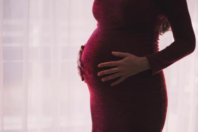 A pregnant woman holding her stomach.