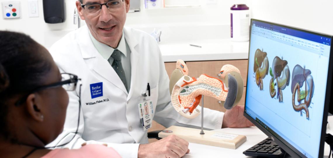 Doctor with patient looking at computer monitor with pancreas images