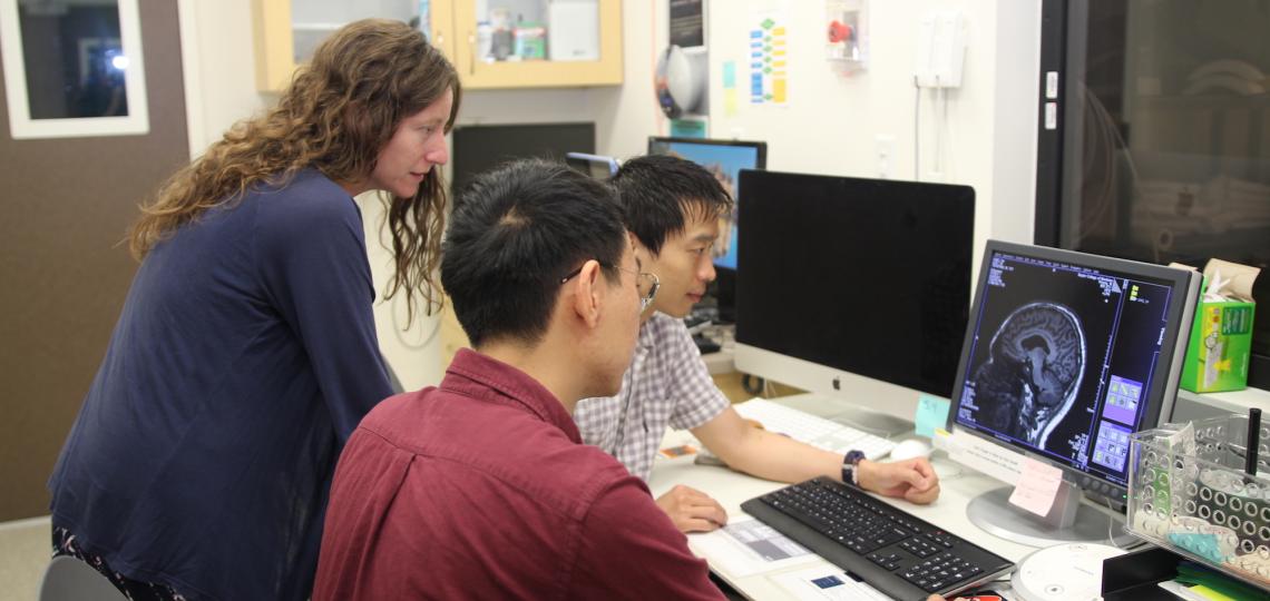 three people looking at a computer screen