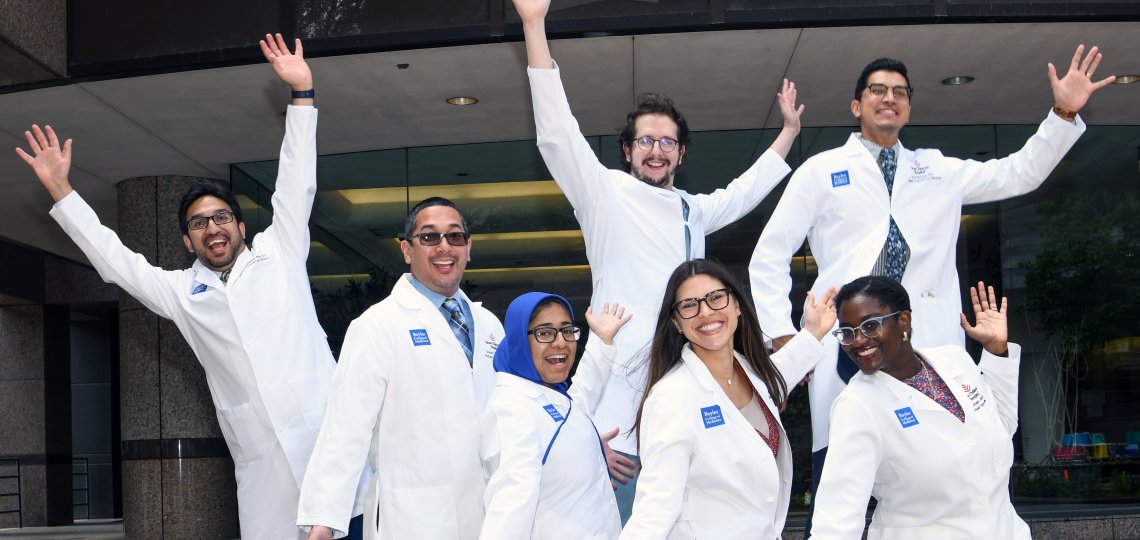 Members of the Pediatric Critical Care Medicine Fellowship pose in a silly fashion, arms waving and looking like they're dancing.