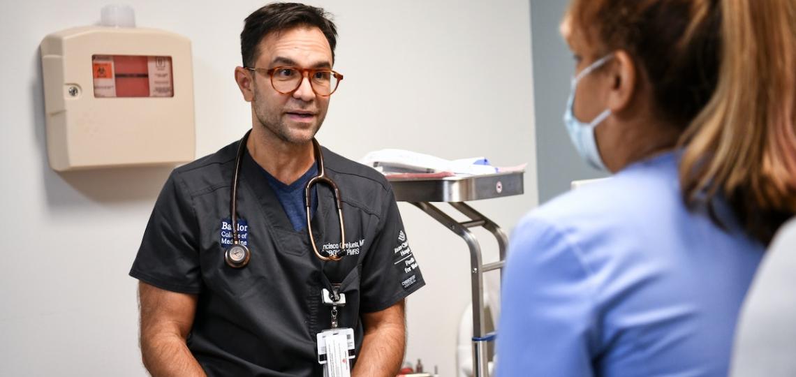 Dr. Francisco Orejuela, director of the Pelvic Health and Wellness Clinic, listens to a patient attentively in clinic.