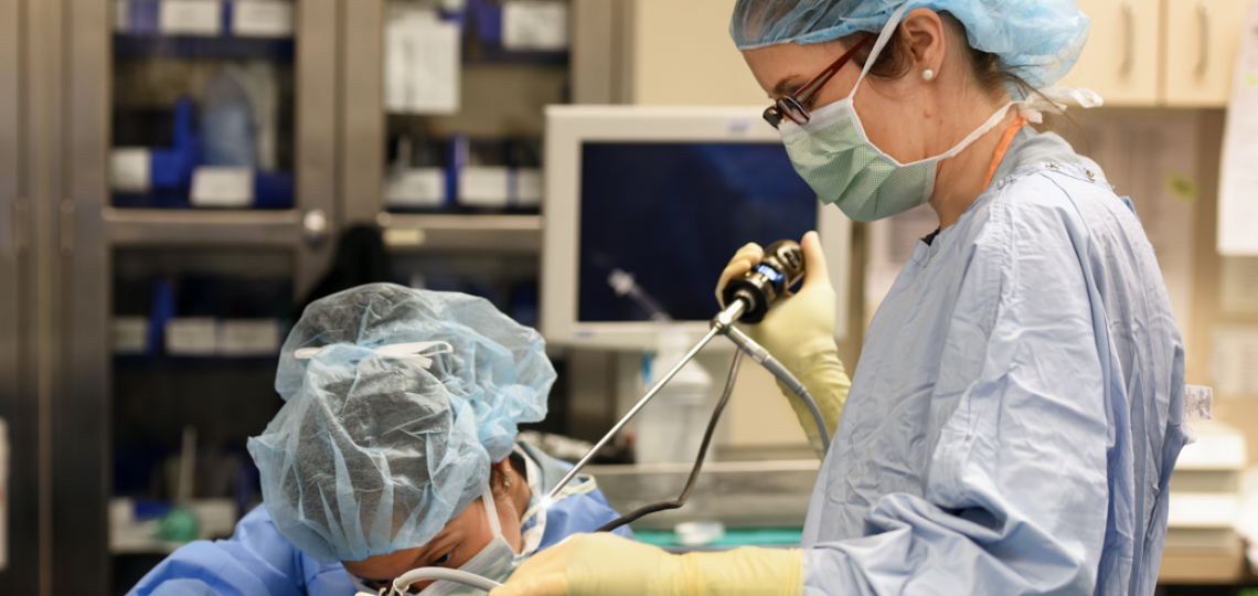 Two surgeons performing a procedure on a patient.