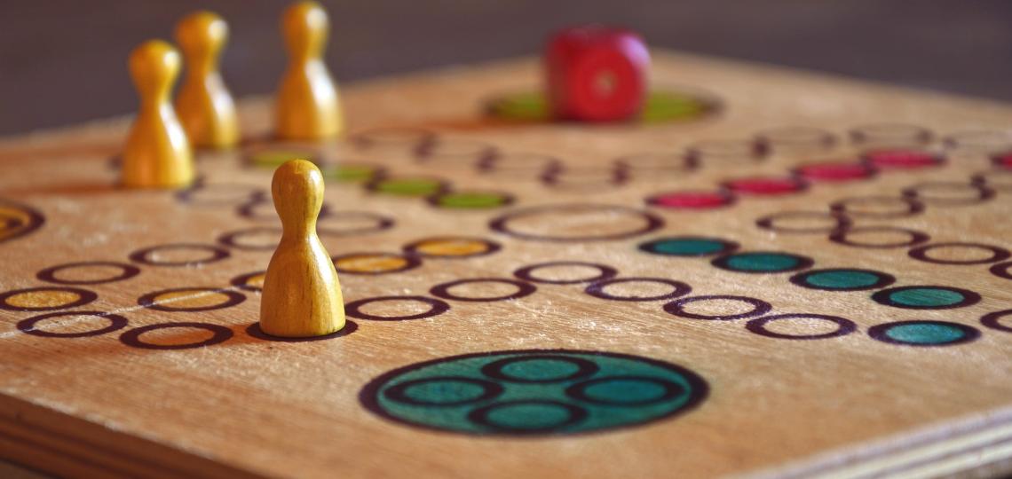 Close up photo of a board game with wooden game pieces 