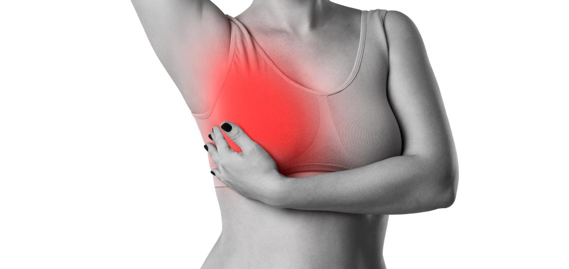 Photo of a woman giving herself a breast exam. 