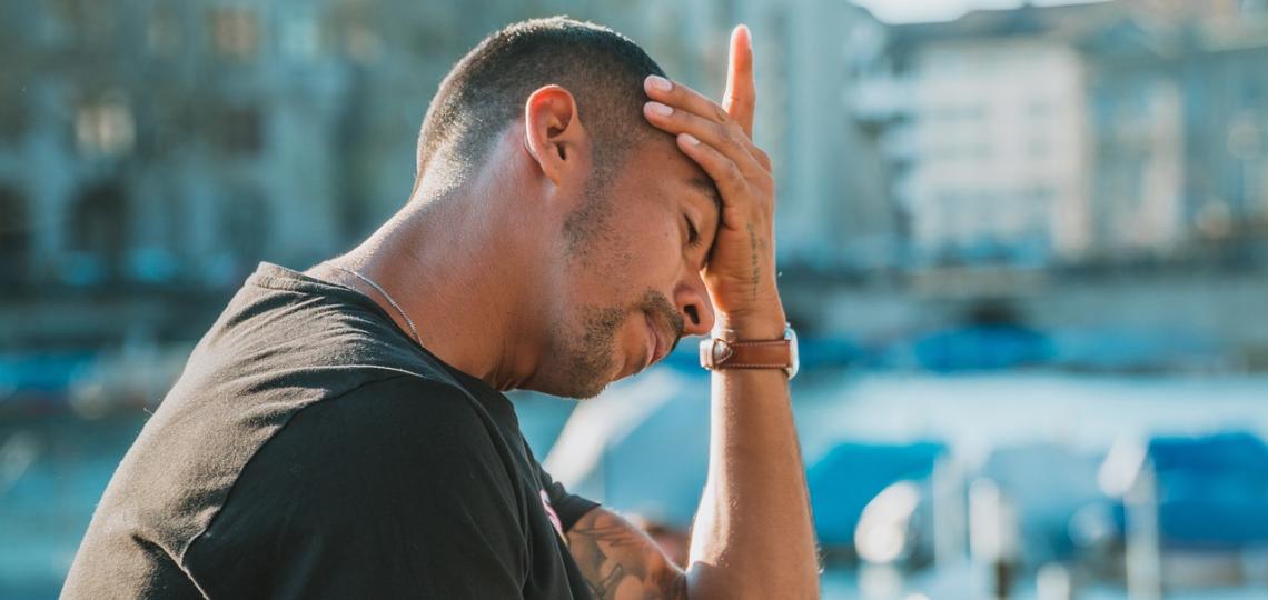 A man holding his head because his head hurts. 