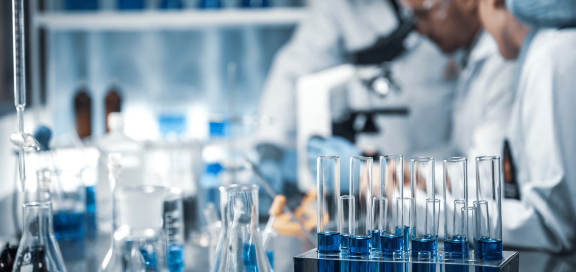 Scientists working in a lab filled with containers of blue liquid