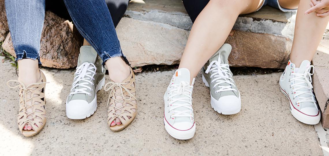 Three teens seated, focused on their shoes
