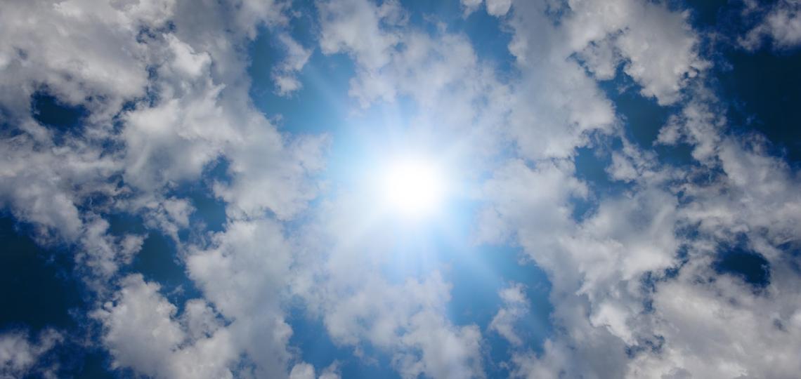 Photo of the sky showing the sun and clouds
