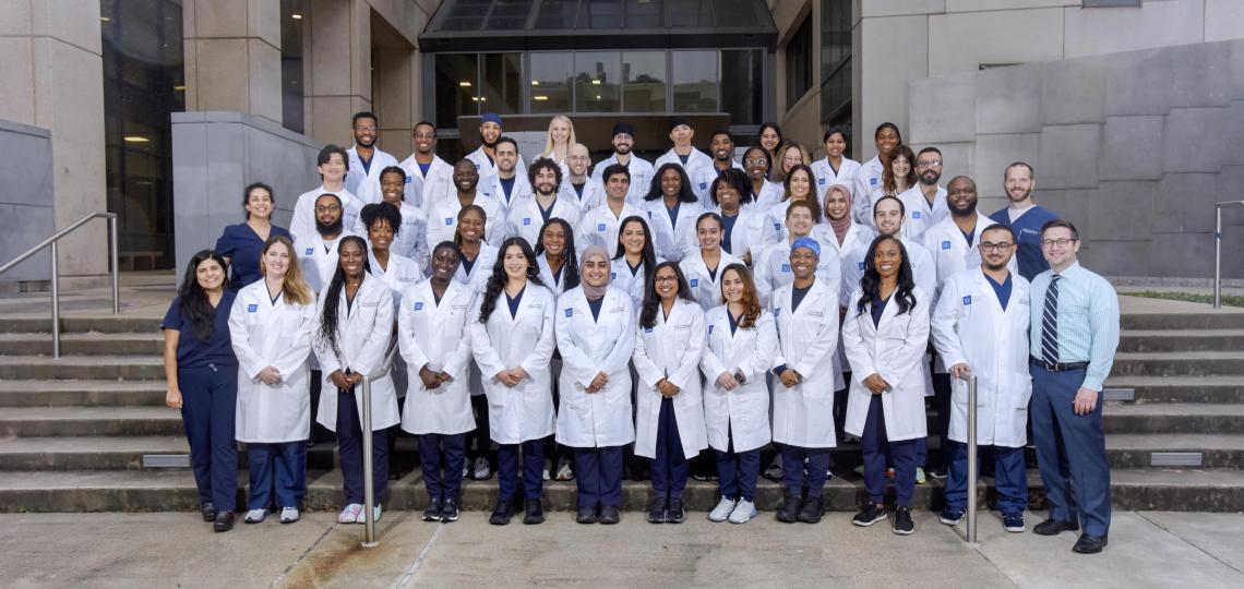 large group of doctors smiling for camera on a set of stairs