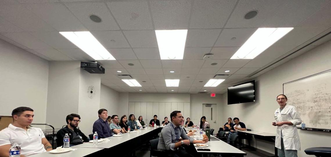 doctor speaking to a room of people at desks