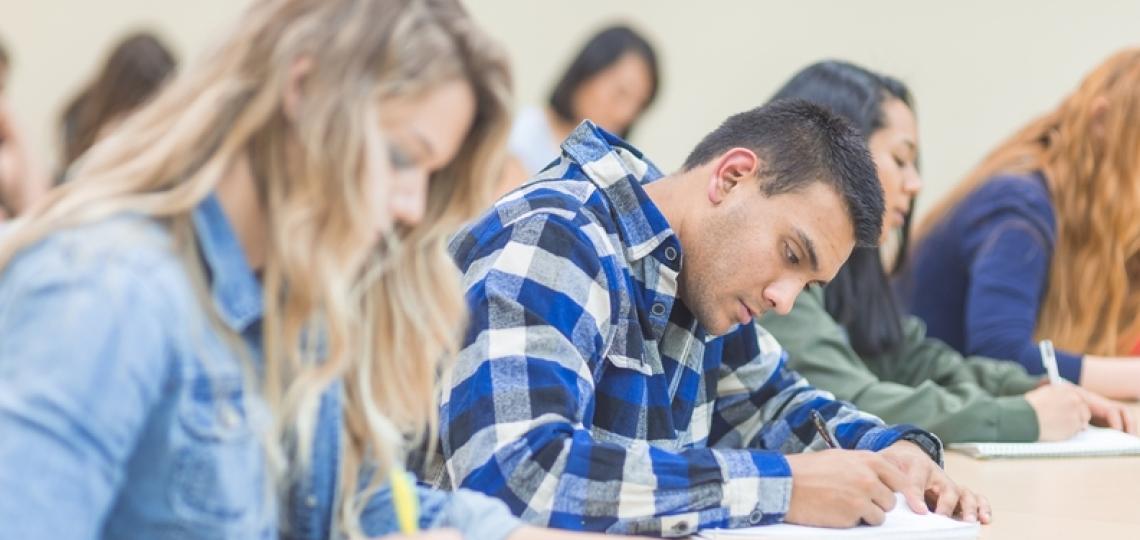 A few students studying carefully in a classroom.