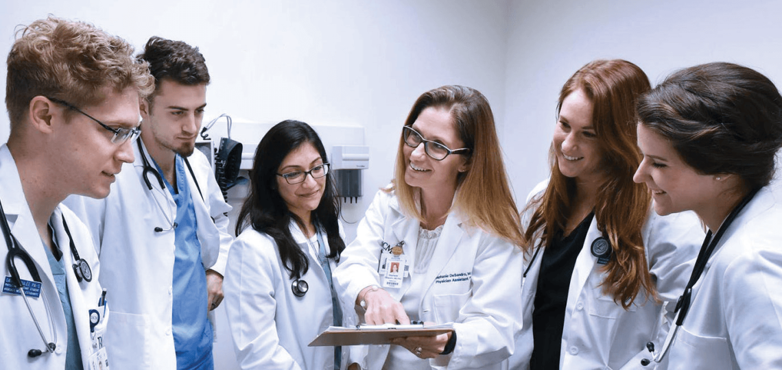 Students and a professor in white coats