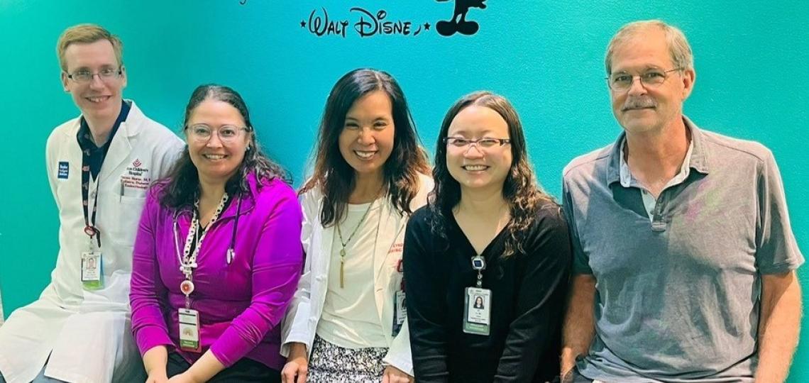 group of people in front of walt disney quote mural