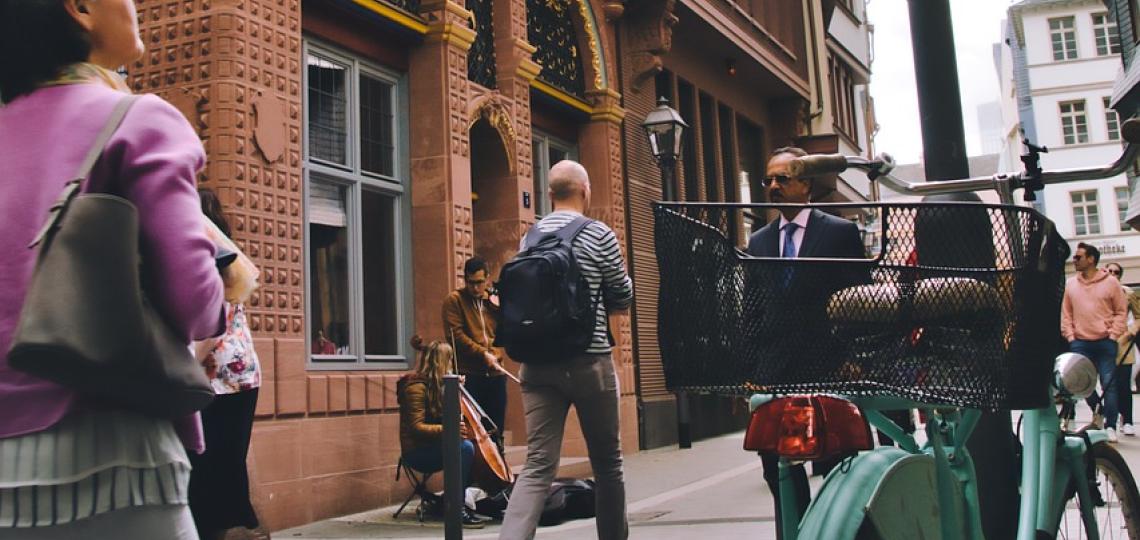 Photo of people walking down a street dressed for work to represent an outdoor commute.