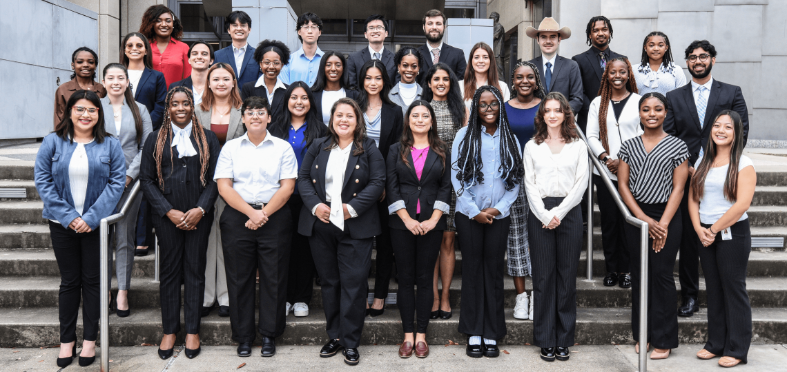 Four rows of students staggered on stairs, smiling
