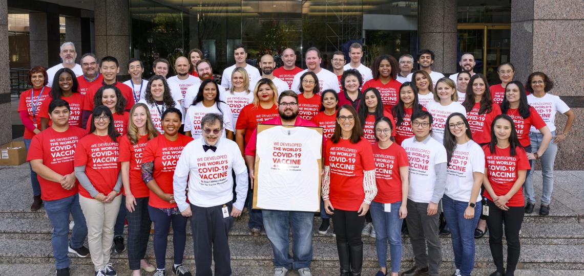 group of tropical medicine faculty members smiling in red and white shirts