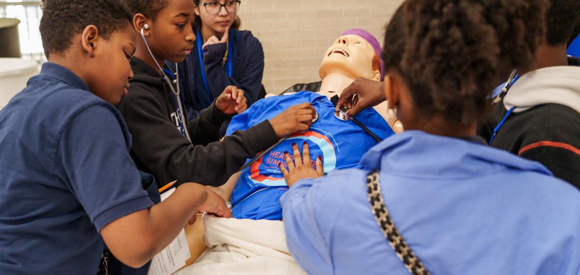 Students from Ryan examine a medical dummy during an open house event