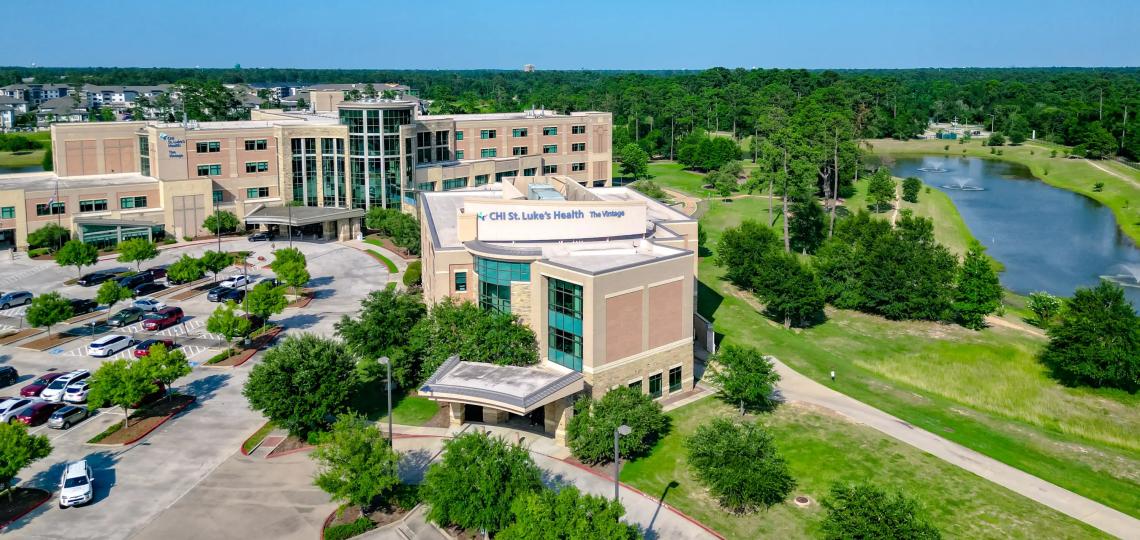 An aerial view of Baylor Medicine at Vintage building and adjacent lake.
