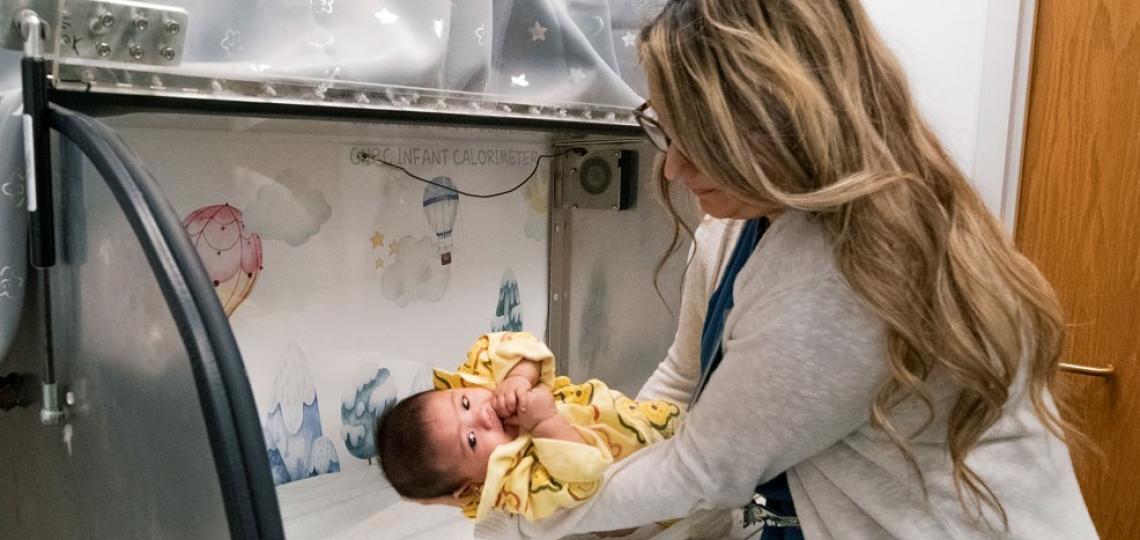 Woman putting an Infant into a Calorimeter