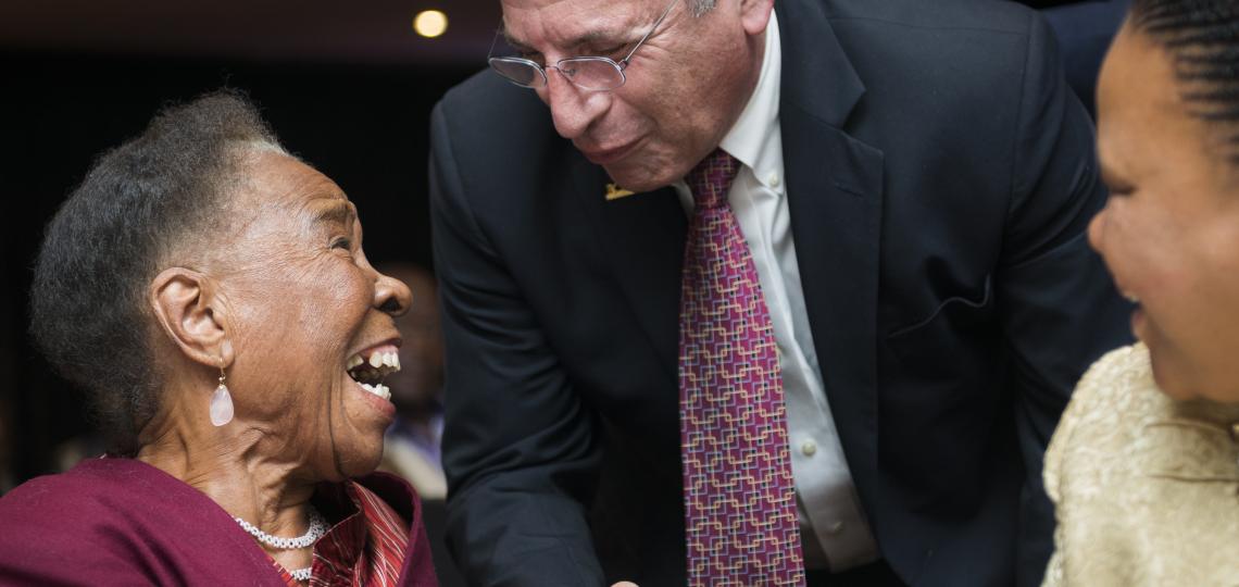 two people shaking hands and smiling