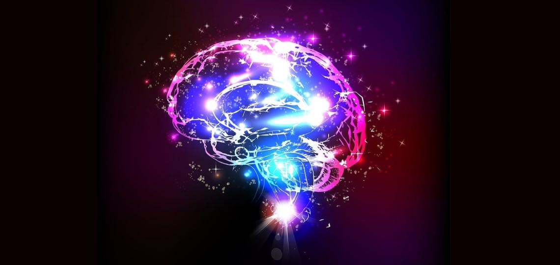 Artists rendition of a brain in pink and blue with what looks like stars inside and outside of the brain to represent activity and memory. 