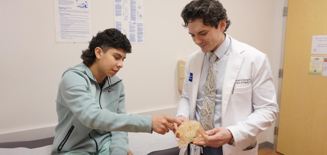 A doctor consulting a patient with an example of a facial prosthesis.