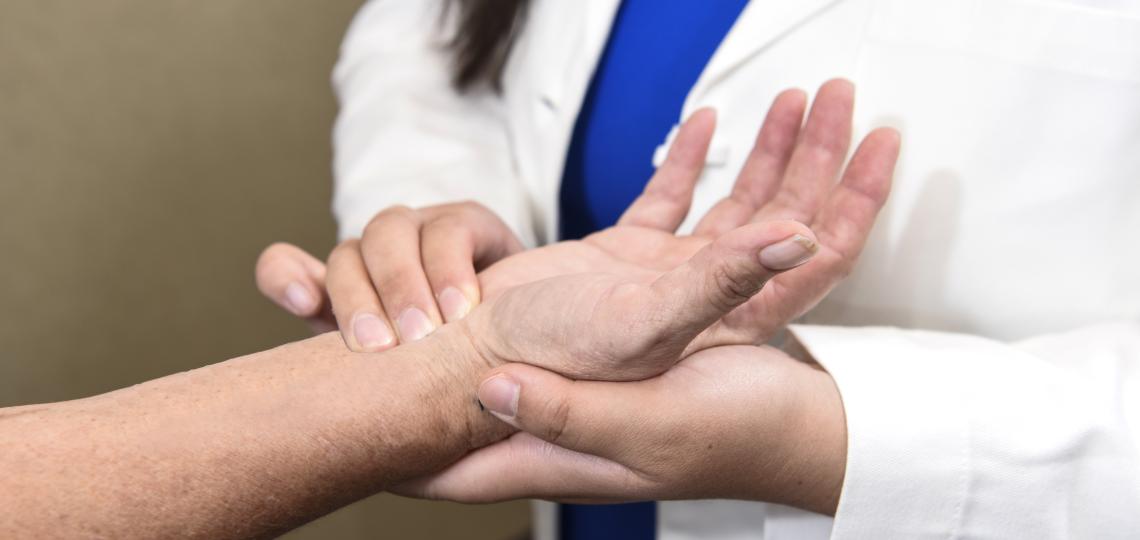 A physician holding the hand of a patient.