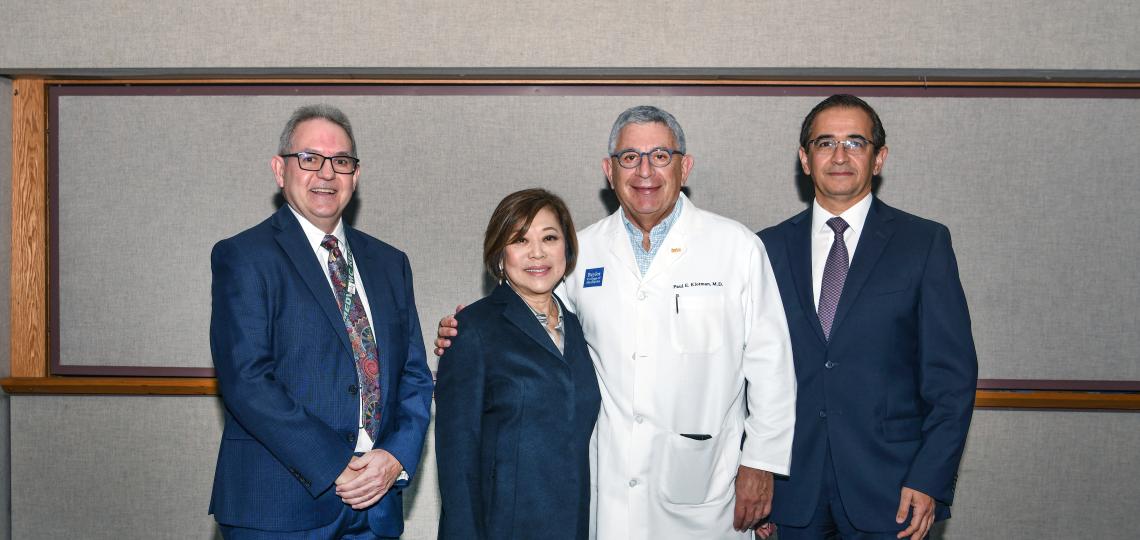 4 people standing next to each other and smiling