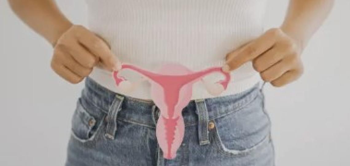 woman holding a paper illustration of a uterus
