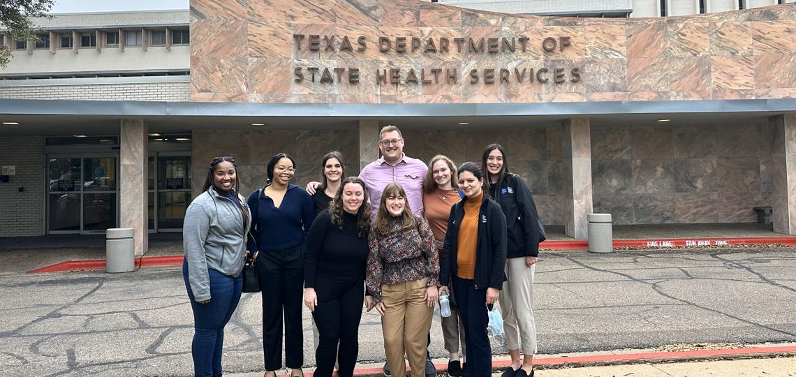Group of students standing in front of a sign that reads "Texas Department of State Health Services".