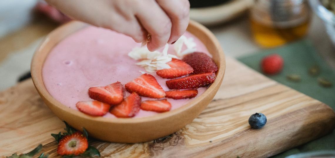 Photo of strawberry yogurt with chopped strawberries and other fruit.
